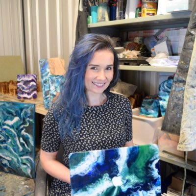Abstract artist decorating olive wood chopping boards with resin.