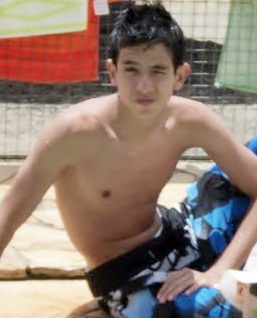 Um menino que brinca com a sua bola
