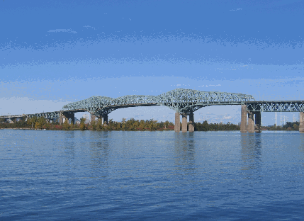 I am a steel truss cantilever bridge with approach viaducts constructed of prestressed concrete beams supporting a prestressed concrete deck paved with asphalt.