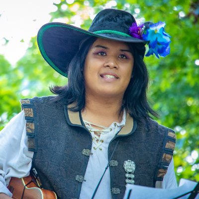 Ryan Canuel (he/him)- A renaissance faire independent performer! Lively songs, deadly puns, and bardic shenanigans. 
Plays a lot of games, and makes them too!