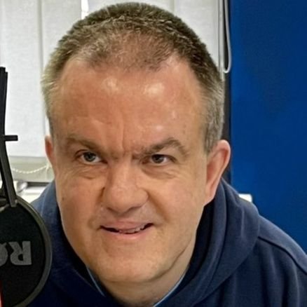Radio presenter in between doing sports news for radio