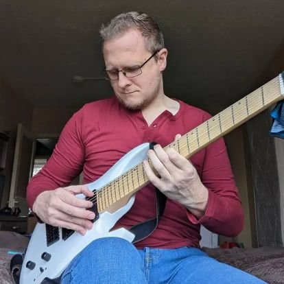Composer. Guitarist. Slurs heavily. Occasional bender. Off/on relationship w. plectrums. Bringing the Messaien 3rd mode back into fashion.