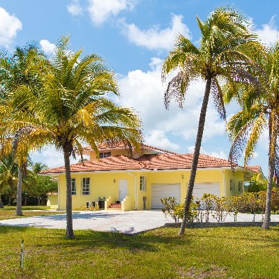 Gorgeous 4 bedroom, 2 story concrete Bahamas home with red tiles is situated on two plots of land on the Ruby golf course on Freeport, Grand Bahama Island.