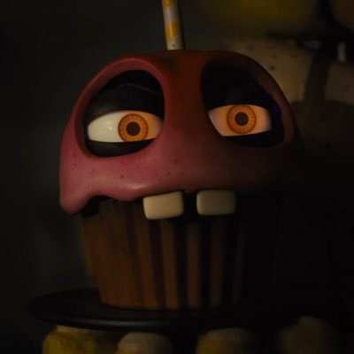 I’m Carl. I’m a vanilla cupcake with pink icing, a yellow striped candle, yellow eyes, and buck teeth. I’m typically seen on a plate held by Chica the Chicken.