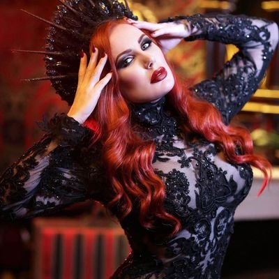 Flame haired, whip wielding disciplinarian, high priestess of kink, owner of Murder Mile studios