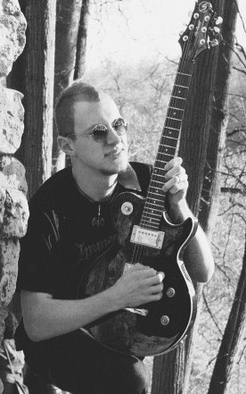 Lead-guitar player with red beard from North.