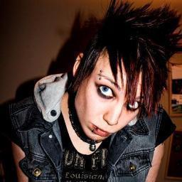 Mohawked girl/boi. Camera monkey. Metal in face, ink on skin. Wears shoes. Fluent in gremlin/dinosaur. Prolific face-licker.