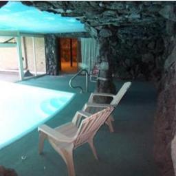 Shamelessly appealing to HGTV/DIY to come reno this 1970s grotto that features funky lava rock walls, indoor/outdoor pool, groovy hot-tub cave & fireplace.