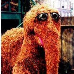 A Snuffleupagus is a woolly mammoth, without tusks or ears, that has a long thick pointed tail, similar in shape to that of a dinosaur or other reptile.