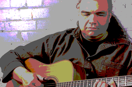 A guy with a bunch of guitars.