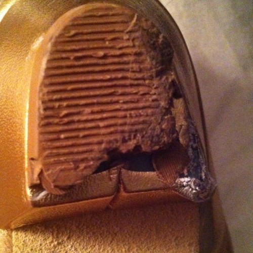 CP Shoes Logo - a yellow worn and broken heel