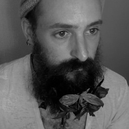 A quixotic peripatetic fool, hirsute and happy, queer.