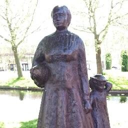 Vrouw met kind, kip en mandje eieren | mijmerend beleef ik de wereld, met mijn rug naar het gemeentehuis en mijn blik naar het stadje