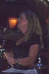 Amanda's wife. Isaac's mom. Drummer for Olde #7 Band.