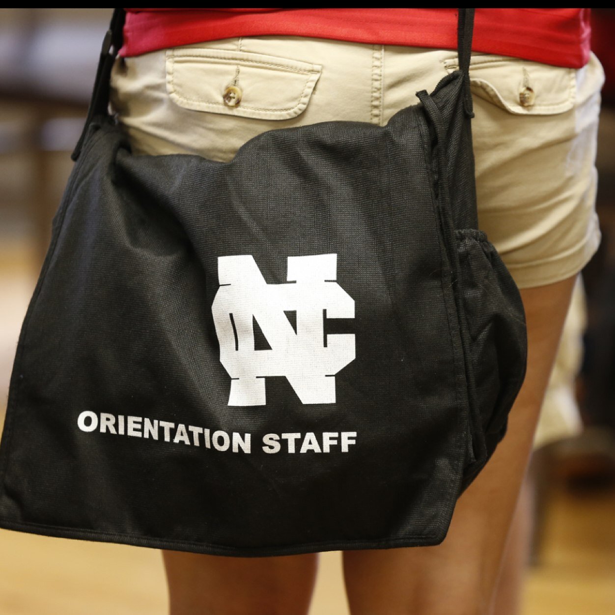 North Central College's red polo staff assisting First-Year & Transfer students and family members during summer orientation and Welcome Week