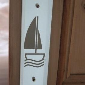 Unique mirrored and coloured glass door fingerplates, sandblasted with our own designs, plus wood and stone doorstops and tables, all designed in Devon!