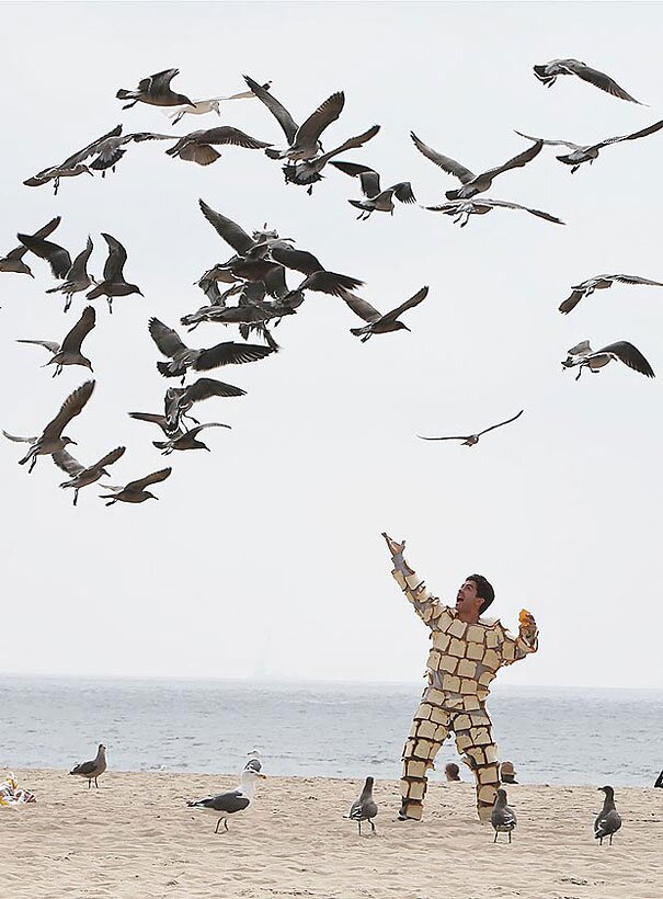 Just a man covered in bread, shouting at the birds.