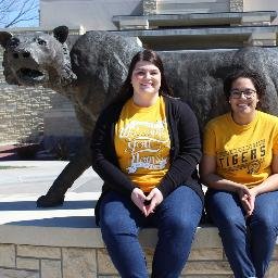 One short girl, sitting on another short girl's shoulders, wearing a long trench coat and trying to be the next Pres & VP of the Fort Hays State student body