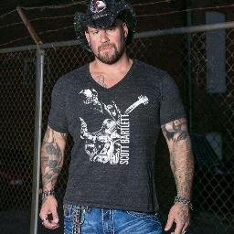 This is Scott Bartlett of Saving Abel fame. His tattooed, rock and roll, no nonsense attitude is now available in a clothing line.