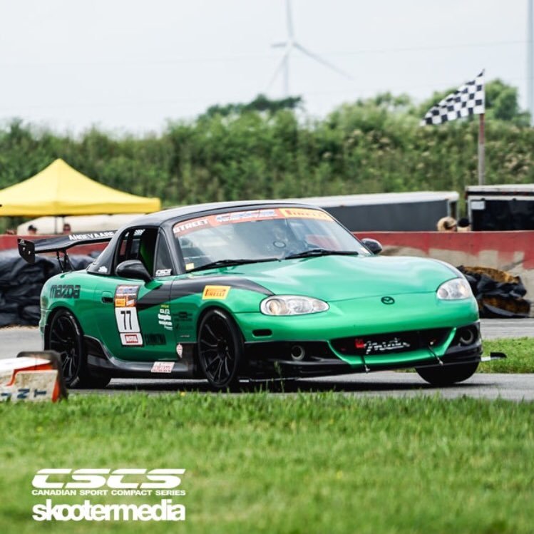 Amateur father-son race team driving a green supercharged Mazda Miata.