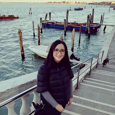 Commessa/cassiera presso negozio di scarpe e abbigliamento.
