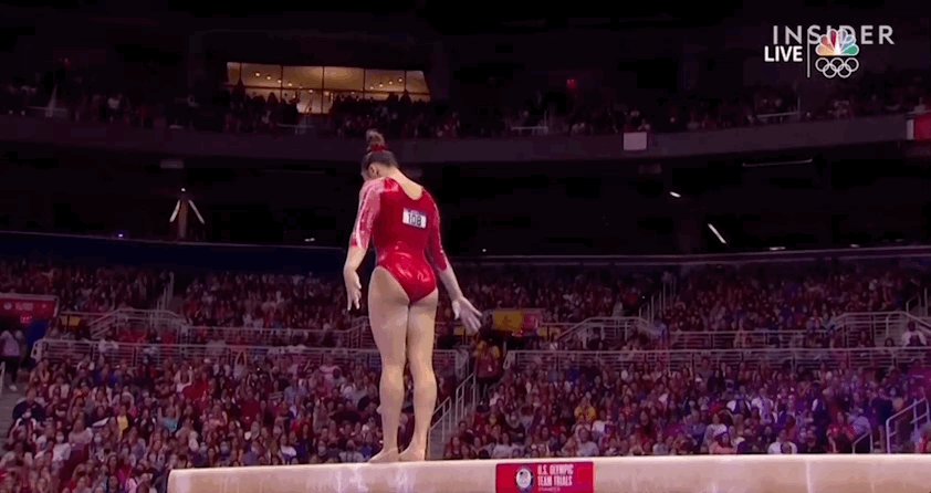 Gif showing Sunisa Lee flipping backwards off a balance beam