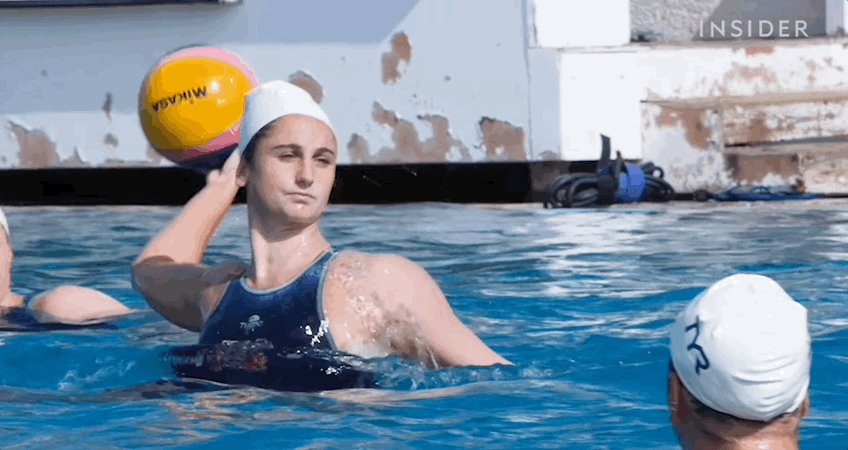 Gif showing a woman throwing a ball during water polo.