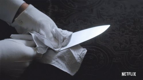 Someone in a pair of white gloves, cleaning the blade of a k