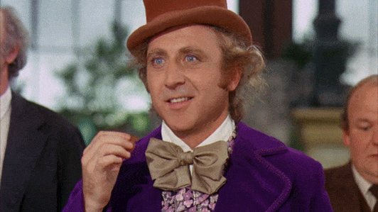 Gene Wilder as Willy Wonka eating popcorn and looking at som