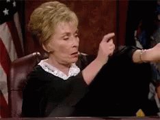 A GIF of Judge Judy impatiently tapping her watch.
