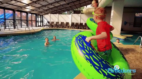 kids with goggles on, with inner tubes, and they jump into p