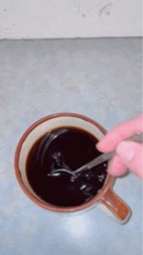 A short gif clip of a white hand using a spoon to stir dark 