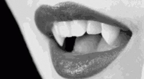A gif of painted lips smiling to fully showcase fangs.