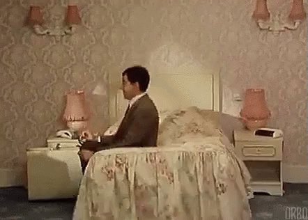 Mr Bean bouncing on a bed