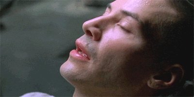 A gif of Keanu Reeves in the movie The Matrix waking up and 