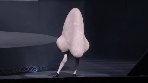 Someone in a giant nose costume with their legs sticking out