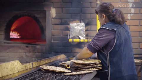GIF; woman flips over freshly baked matzo.