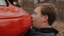 Ein Mann küsst sein Auto.